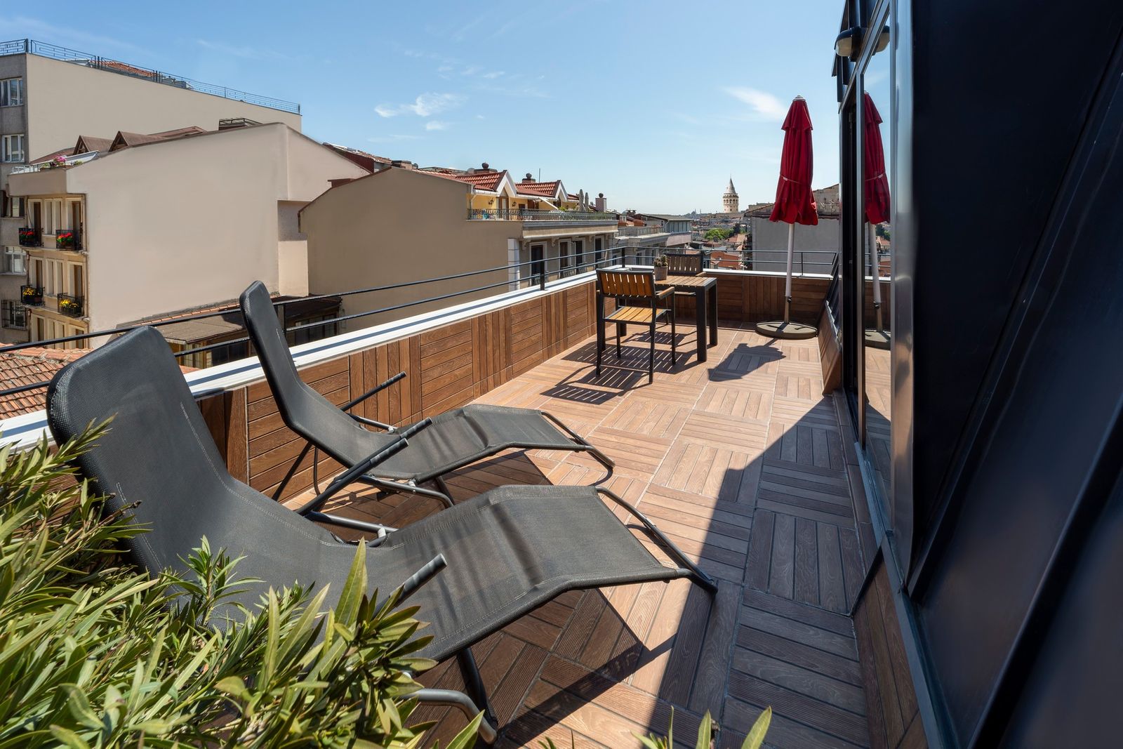 A second angle on the Terrace Suite's private terrace, taken in the early evening with the city light warm on the parapet wall.