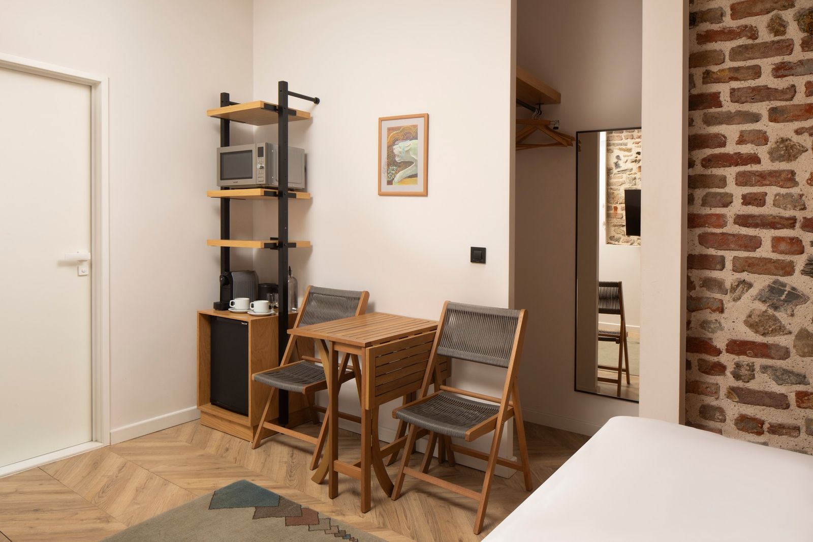 The dining and kitchenette corner of the Studio Flat — small oak table for two, induction hob, espresso machine on the counter.