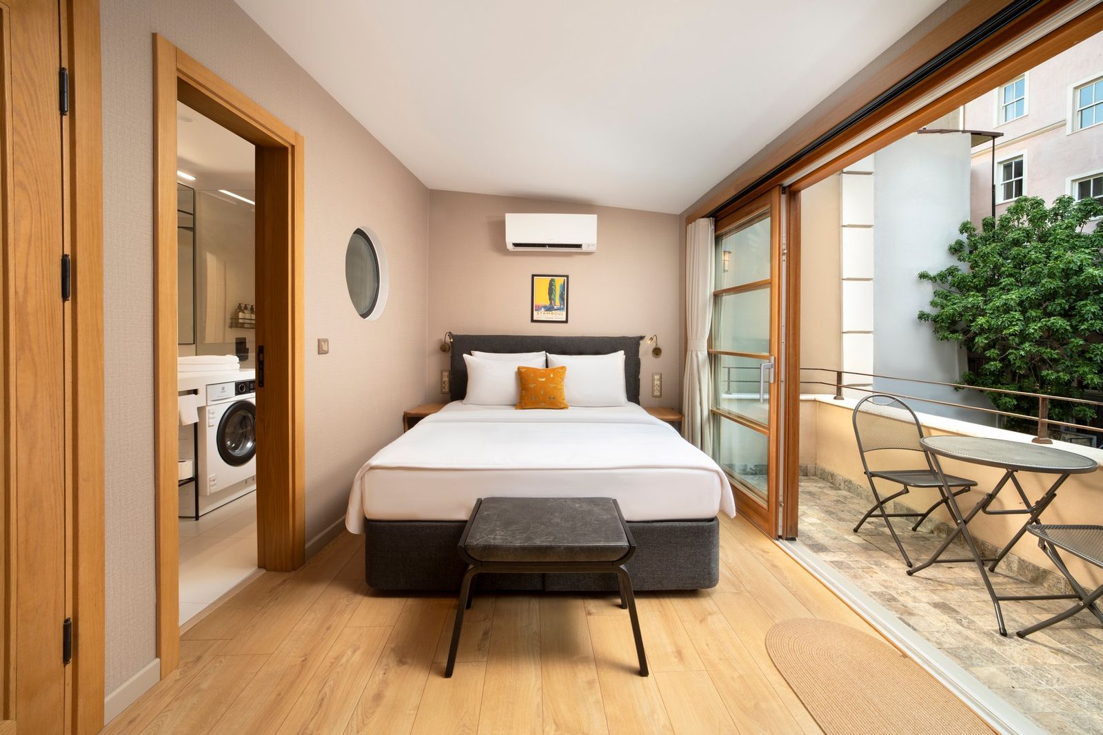 The bed of the Balcony Apartment with the French doors of the balcony behind, the dome of the hamam framed in the doorway.