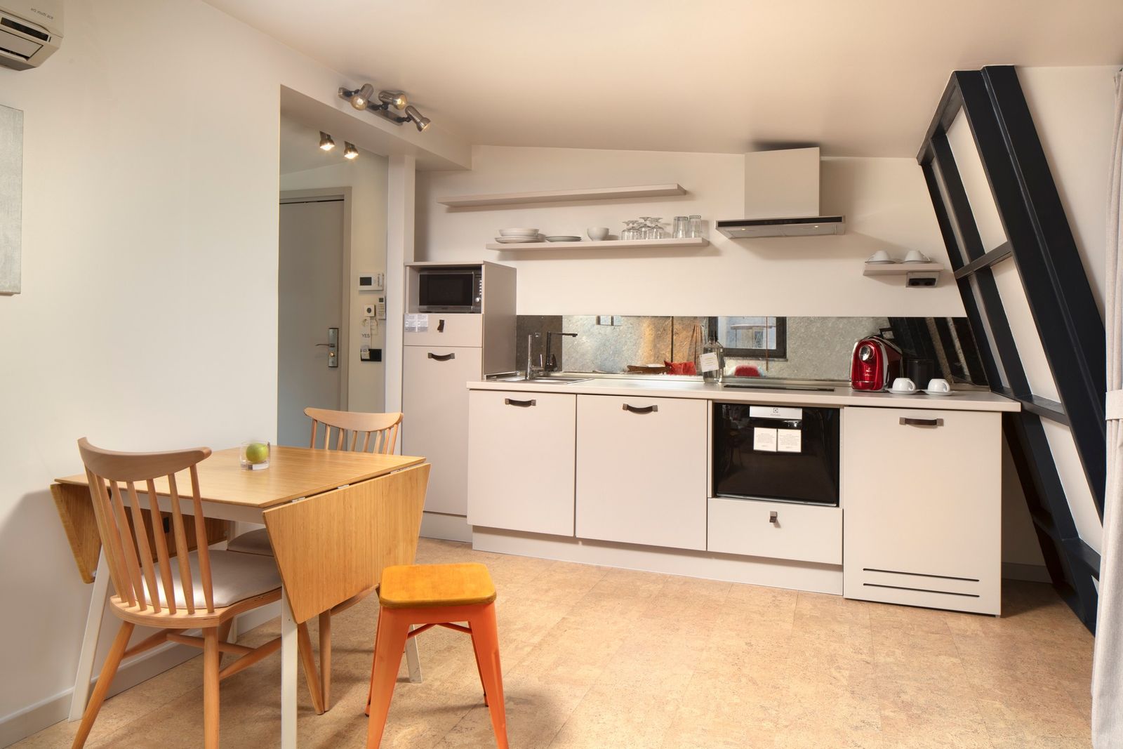 The kitchenette in the Terrace Suite — full-height cabinetry, induction hob, espresso machine on the counter.