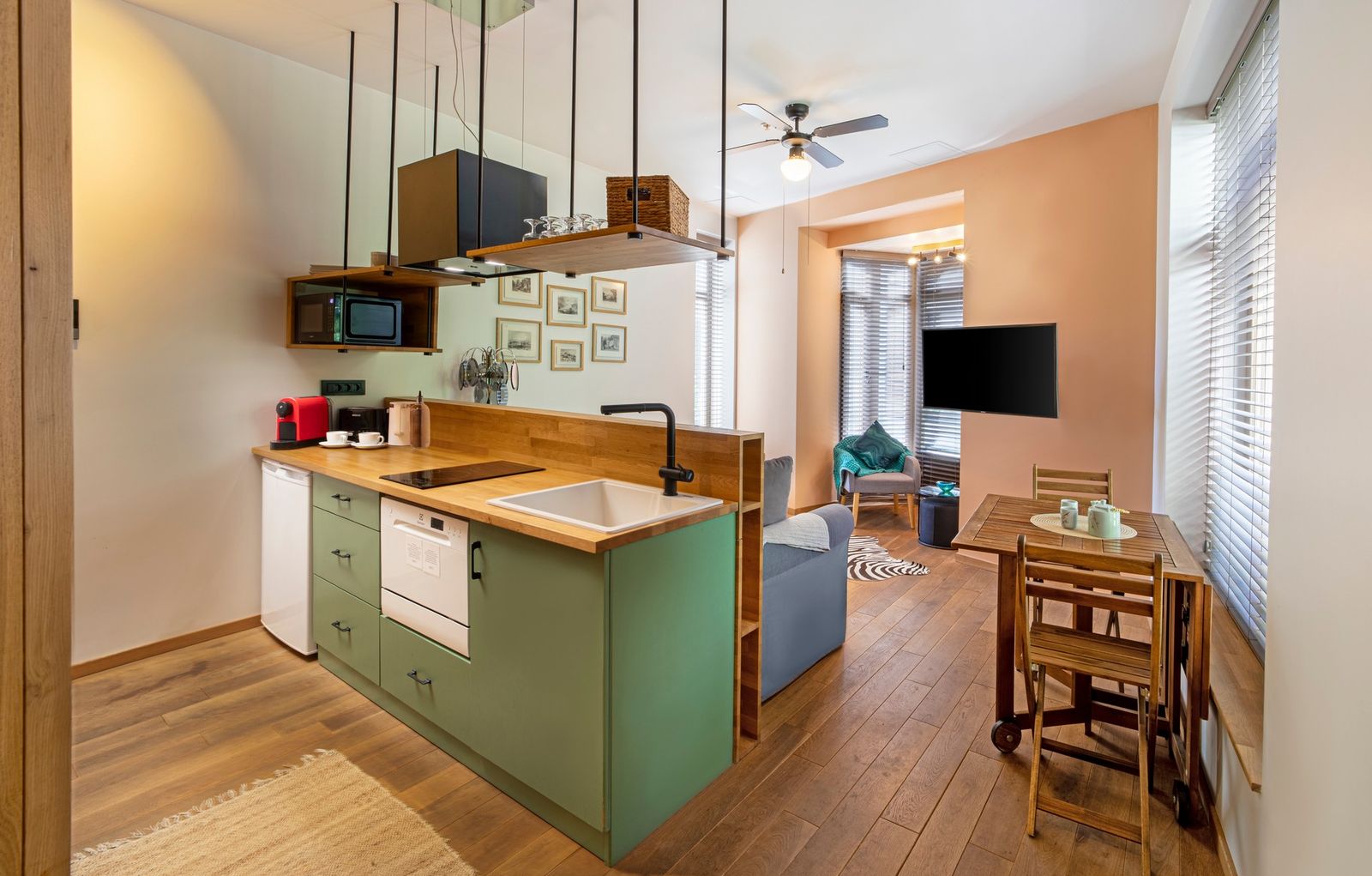 The Duplex Residence kitchen — full-height cabinetry, induction hob, oven below, a small island for two.