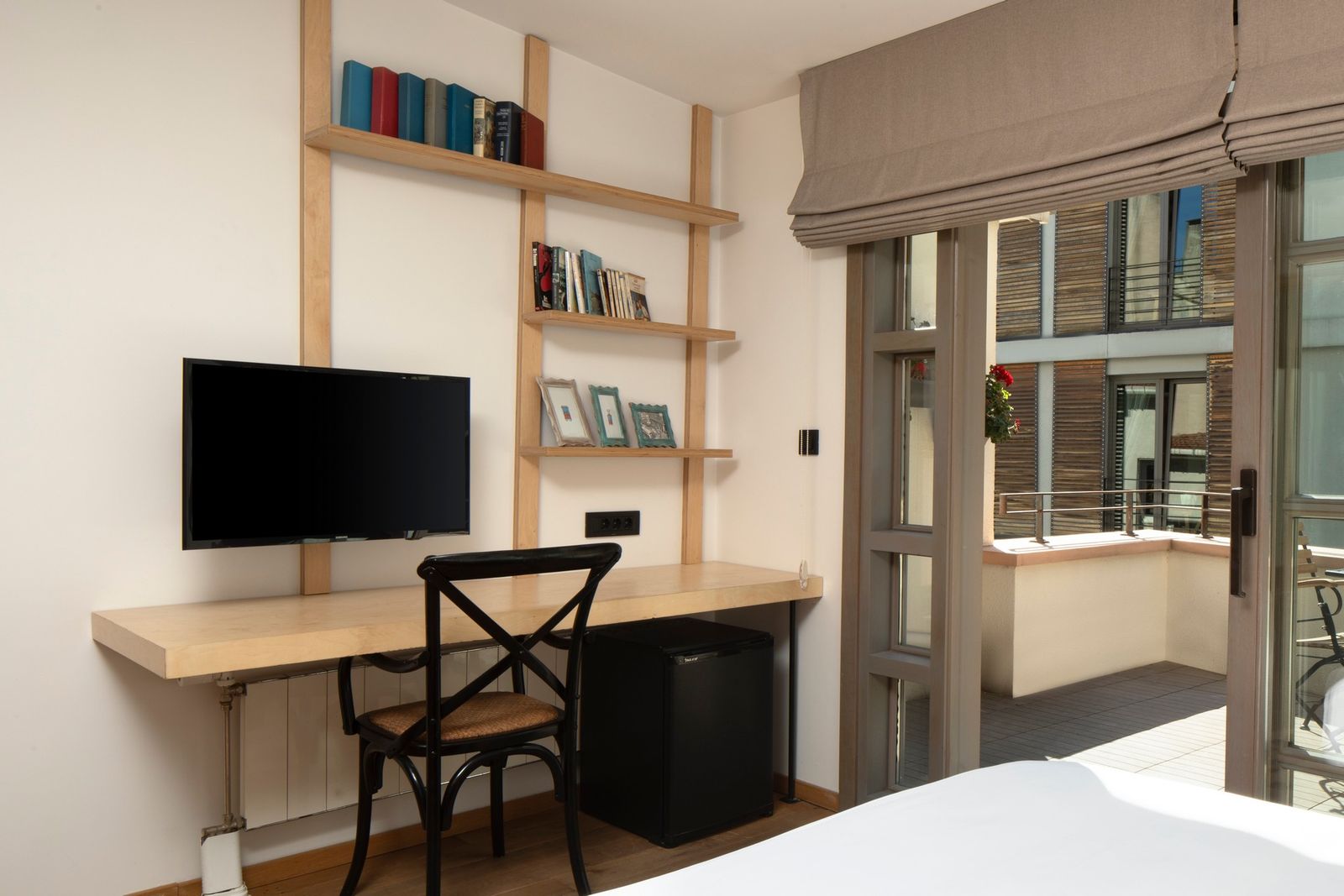 A close view of the upper-level writing desk in natural light, with a stacked notebook and a small brass lamp.
