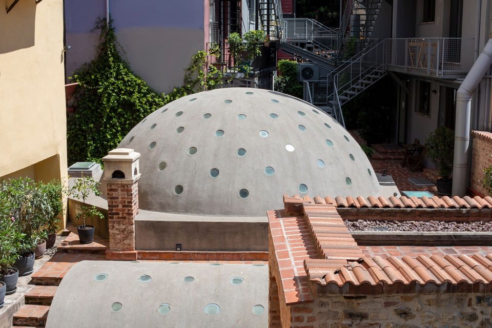 The exterior dome of the Çukurcuma Hamamı seen from the rooftop, with the lead cladding catching the late afternoon sun.